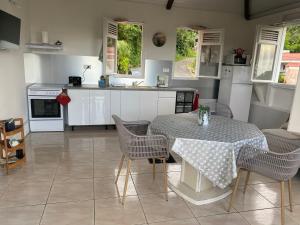 a kitchen with a table and chairs and a kitchen with a counter at Le cocon de Cathy in Rivière-Pilote