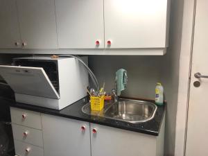 a kitchen counter with a sink and a microwave at Billigst i Arendal sentrum uten dusj næringslokaler klinikk og verksted in Arendal