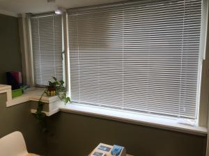 a window with blinds on it with a table in front of it at Billigst i Arendal sentrum uten dusj næringslokaler klinikk og verksted in Arendal