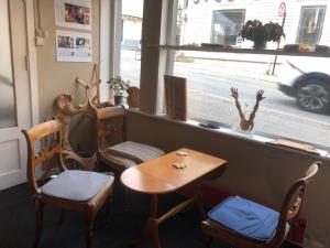 a table and chairs in front of a window at Billigst i Arendal sentrum uten dusj næringslokaler klinikk og verksted in Arendal