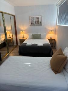 a bedroom with a large bed and two lamps at Tall Timbers Motel in Dungog