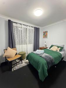 a bedroom with a green bed and a window at Nestled on Smith in Stanthorpe