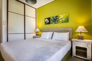 a bedroom with a bed and a yellow wall at Deluxe Kefalonia Apartment Apartment Leyland 1 Bedroom Pool And Sea View Karavomilos in Karavomylos