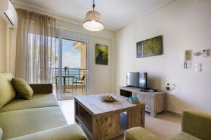 a living room with a couch and a tv and a table at Deluxe Kefalonia Apartment Apartment Leyland 1 Bedroom Pool And Sea View Karavomilos in Karavomylos