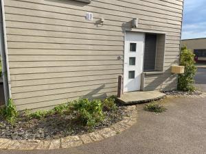 ein Haus mit einer weißen Tür und einer Einfahrt in der Unterkunft Chambre superbe à découvrir au cœur des Vosges uni in La Celle-sous-Gouzon
