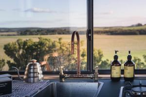 three bottles of wine sitting on a kitchen sink at Beach Front Off-Grid Cabin on Kangaroo Island - Xanthe in Antechamber Bay