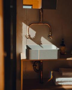 a sink in a bathroom with a copper piping at Beach Front Off-Grid Cabin on Kangaroo Island - Xanthe in Antechamber Bay