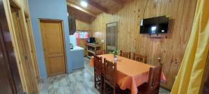 a dining room with a table and chairs and a television at JuanSe Cabaña in Ituzaingó
