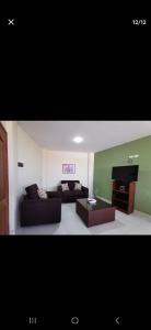 a living room with a couch and a piano at Departamento amplio y céntrico in Cochabamba