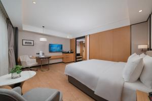 una camera d'albergo con un letto bianco e una scrivania di Beijing Xiamen Mansion Yihao Hotel a Pechino