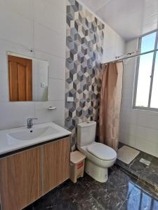 a bathroom with a toilet and a sink at Departamento amplio y céntrico in Cochabamba