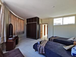 a hotel room with two beds and a television at Departamento amplio y céntrico in Cochabamba