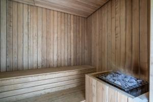 a wooden sauna with a wooden bench in it at Sunny Muse by Betterplace in Canggu