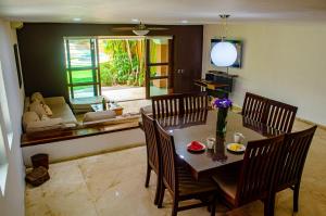 a dining room with a table and chairs and a couch at Yacht House in Cancún