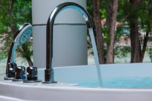 un lavandino del bagno con un rubinetto e uno specchio di CORAL ISLAND 1棟貸し 天然ビーチまで徒歩5秒 ジャグジー付きVilla a Nago