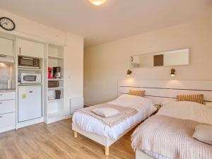 due letti in una piccola stanza con cucina di Studio rénové et climatisé avec balcon pour 2 personnes - FR-1-841-24 a Barbotan-les-Thermes