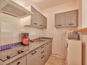 eine Küche mit weißen Schränken, einer Spüle und einem Kühlschrank in der Unterkunft Appartement T2 avec balcons à Barbotan, idéal pour 2 personnes - FR-1-841-49 in Barbotan-les-Thermes + 8 Fotos