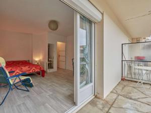 Zimmer mit einem Bett und einer Glasschiebetür in der Unterkunft Appartement T2 avec balcons à Barbotan, idéal pour 2 personnes - FR-1-841-49 in Barbotan-les-Thermes
