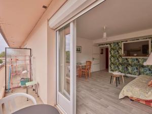 ein Wohnzimmer mit einer Glasschiebetür und einem Tisch in der Unterkunft Appartement T2 avec balcons à Barbotan, idéal pour 2 personnes - FR-1-841-49 in Barbotan-les-Thermes