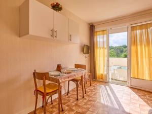 a dining room with a table and chairs and a window at Studio lumineux avec balcon exposé sud pour 2 personnes - FR-1-841-46 in Barbotan-les-Thermes