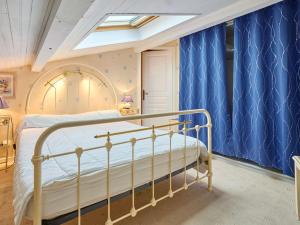 a bedroom with a bed with blue curtains at T2 bis lumineux avec véranda, parking gratuit, wifi, proche nature - FR-1-841-33 in Barbotan-les-Thermes