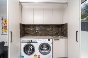 a kitchen with a washing machine and a sink at 3BR Home near Canberra Hospital and Parliament - Hosted by CanStay in Harman