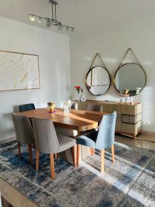 a dining room with a wooden table and two mirrors at Mivida Emaar New Cairo For Rent in New cairo