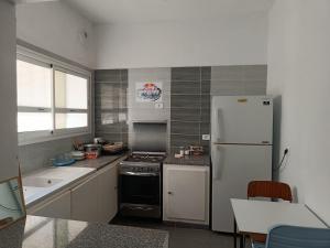 a kitchen with a stove and a white refrigerator at Studio a Hammamet climatise in Tunis