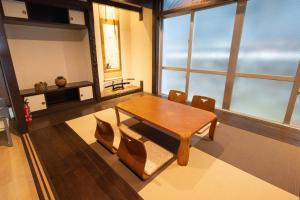 a dining room with a wooden table and chairs at エイトハウス辻 in Naha