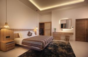 a hotel room with a bed and a mirror at Casa Vana Villas Bali byFaba in Munggu