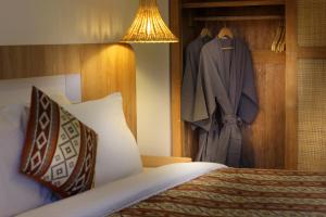 a bedroom with a bed and a suit hanging on a wall at Casa Vana Villas Bali byFaba in Munggu
