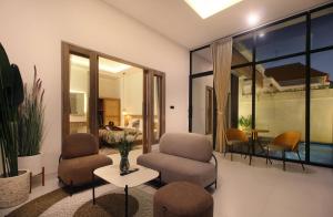 a living room with two chairs and a table at Casa Vana Villas Bali byFaba in Munggu +20 photos
