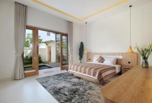a bedroom with a bed and a large window at Casa Vana Villas Bali byFaba in Munggu