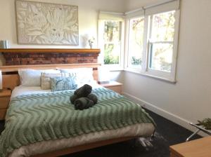 Rubicon Views Cottage في Acheron: دمية دب ملقاة على سرير في غرفة النوم