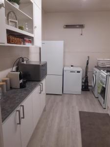 Rubicon Views Cottage في Acheron: مطبخ بخزائن بيضاء ومغسلة وثلاجة +5 صور