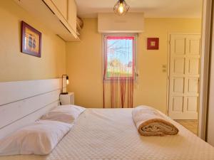 - une chambre avec un lit avec deux oreillers et une fenêtre dans l'établissement Studio T1 Bis cosy pour 2, Wi-Fi et parking, animaux admis - FR-1-841-68, à Barbotan-les-Thermes