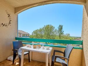 a table and chairs on a balcony with a view at T1 bis moderne avec balcon, Wifi, 2 pers - FR-1-841-78 in Barbotan-les-Thermes