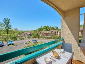 a table on a balcony with a view of a parking lot at T1 bis moderne avec balcon, Wifi, 2 pers - FR-1-841-78 in Barbotan-les-Thermes +5 photos