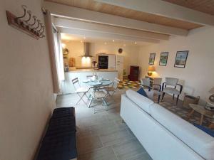 a living room with a couch and a table and chairs at Maison de charme au centre d'Étel - Idéale pour famille - FR-1-479-234 