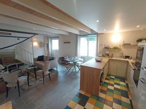 a room with a kitchen and a living room with a table at Maison de charme au centre d'Étel - Idéale pour famille - FR-1-479-234 