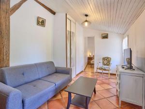a living room with a blue couch and a table at Charmant T2 avec terrasse fleurie, WiFi, animaux admis - FR-1-841-81 in Barbotan-les-Thermes