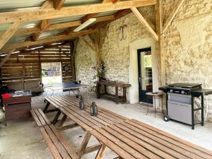a room with a picnic table and a grill at Gîte de charme avec animaux admis, proche châteaux de la Loire - FR-1-381-627 in Courcelles-de-Touraine