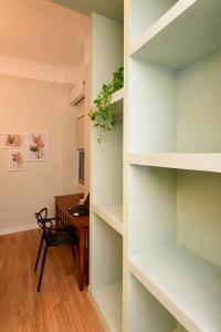 una habitación con escritorio y una habitación con estanterías en Loft no Centro do Rio de Janeiro, a 2 min do metrô Cinelândia, en Río de Janeiro