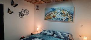 a bedroom with a bed and a painting on the wall at MeNTA GLAMPING in Sasaima