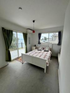 a bedroom with a bed and a large window at PROTY Beach House 琵琶湖のコテージ in Minami-komatsu