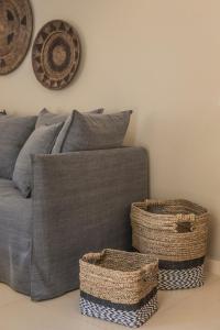 a couch with two baskets on the side of it at Deluxe Kefalonia Apartment Apartment Canella 1 Bedroom Outdoor Pool Karavomilos in Karavomylos