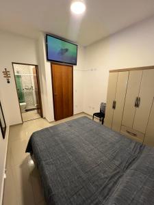 a bedroom with a bed and a flat screen tv at Casa com piscina, 700M da praia in Peruíbe +40 photos