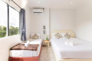 una camera da letto con due letti e una finestra di 6BR Pool Villa - Karaoke and Pool Table near Golf a Chiang Mai