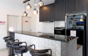 una cucina con armadi neri e un bancone con sgabelli di 6BR Pool Villa - Karaoke and Pool Table near Golf a Chiang Mai