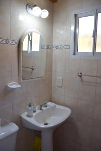 a bathroom with a sink and a mirror at Dunas Norte Departamentos in Balneario El Condor